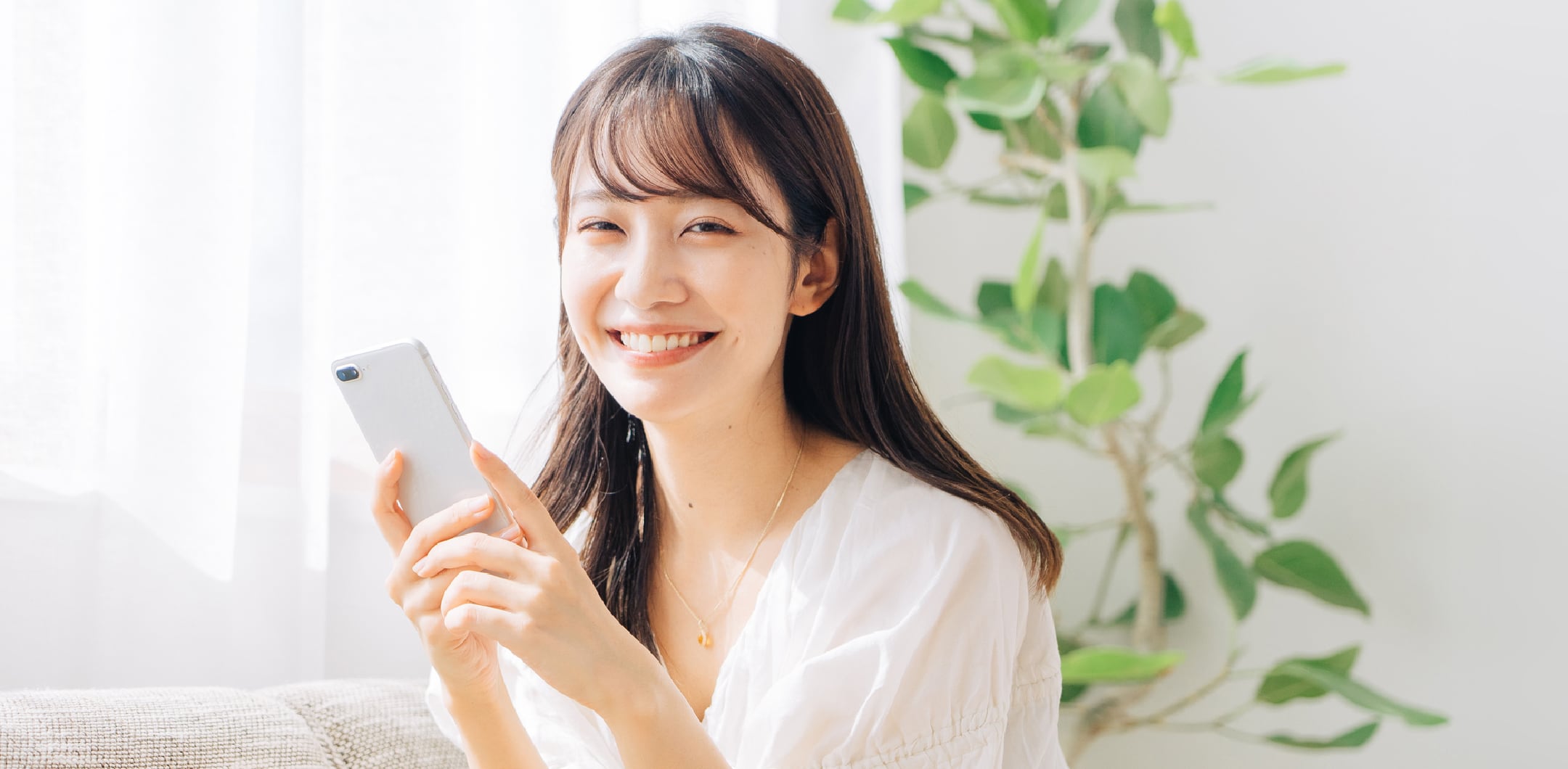 スマートフォンを持ち笑顔の女性